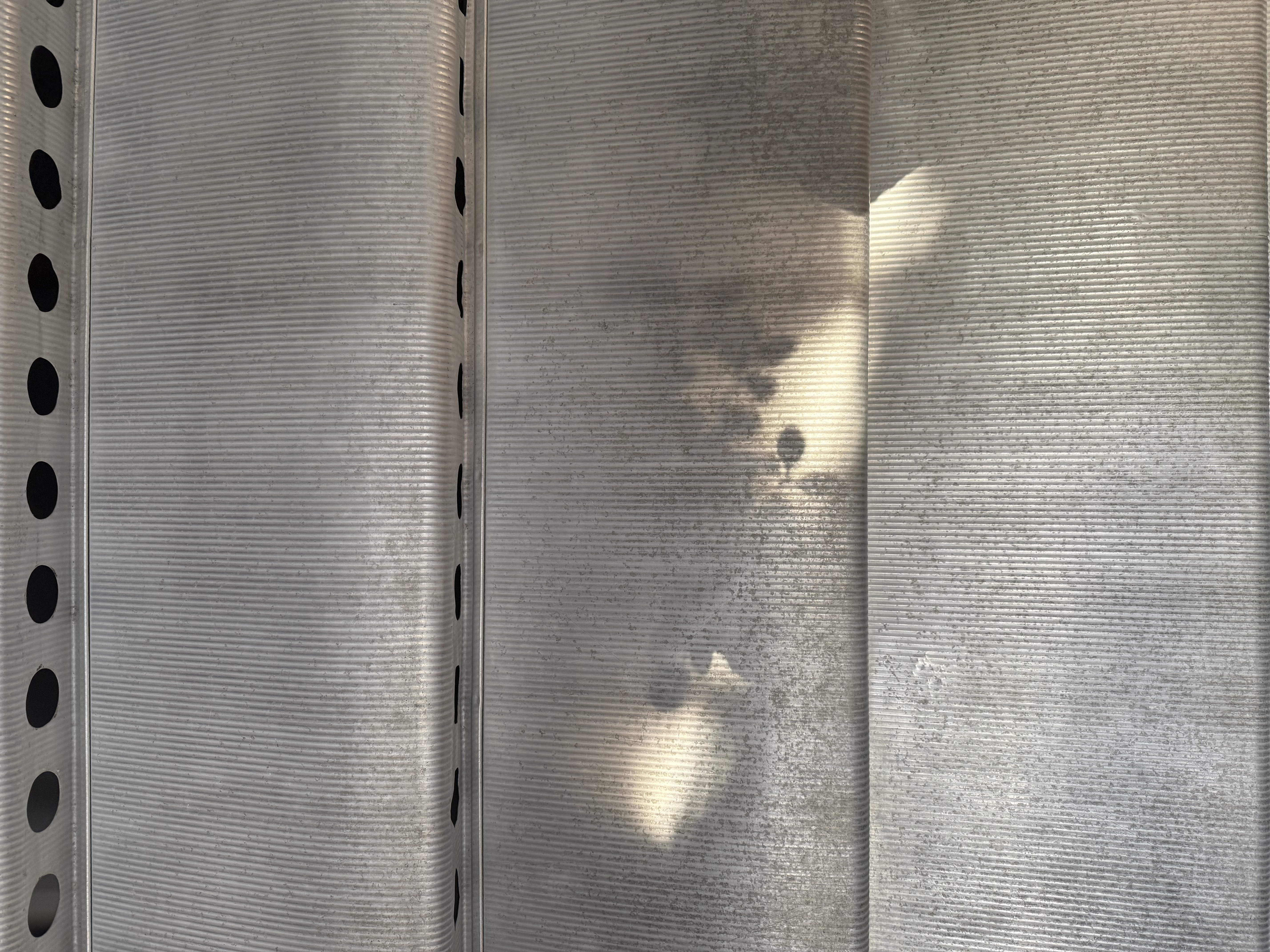 Jean Prouvé aluminium louvre surface — warm amber patina detail